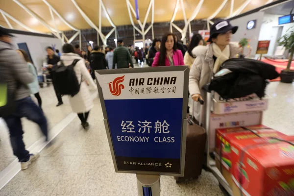 乗客が搭乗券を取得に並ぶし 自分の荷物をチェックインしている中国 上海市に上海浦東国際空港で中国国際航空のカウンターの前で 2016 — ストック写真