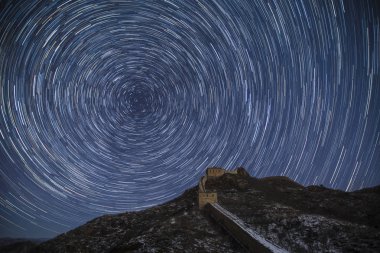 Landscape of the Jinshanling Great Wall in the snow below the starry sky in Luanping county, Chengde city, north China's Hebei province, 23 November 2016 clipart