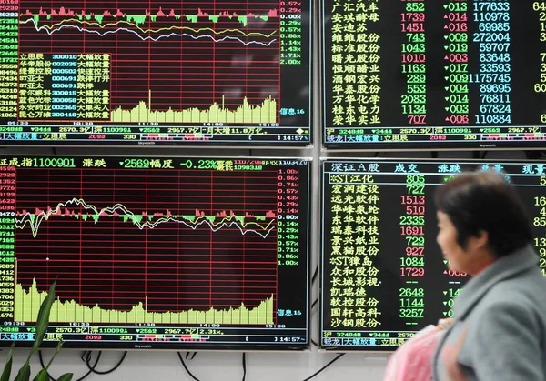 中国の投資家は 中国東部の江西州淵江市の株式仲買家で 株式の価格 価格上昇のための赤と価格下落のための緑 を示す電子ディスプレイを過去に歩いて 11月30日2016 — ストック写真