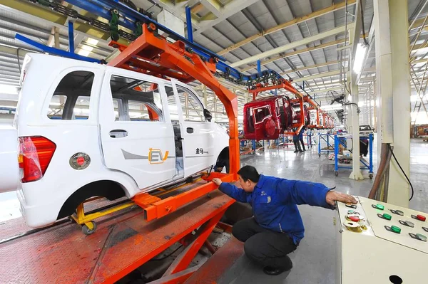 中国の労働者は 2016年12月1日 中国東部山東省のWeifang市の自動車工場で組み立てラインに電気自動車を組み立てます — ストック写真