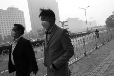 In this black and white picture, pedestrians wearing face masks against air pollution walk on the street in heavy smog in Beijing, China, 4 November 2016 clipart