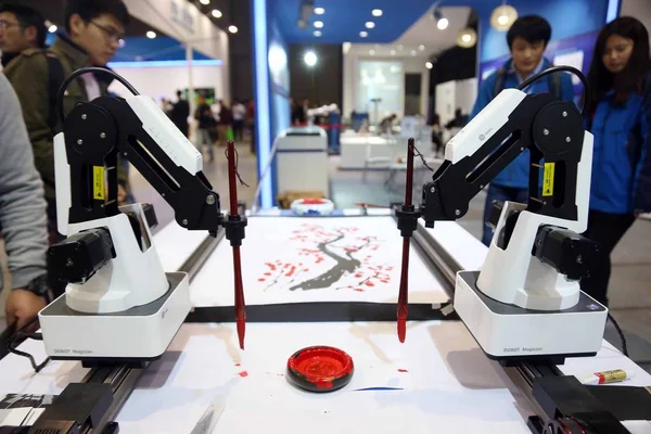 机器人武器在2016年11月1日于中国上海举行的第十八届中国国际工业博览会上画一幅中国传统绘画 — 图库照片