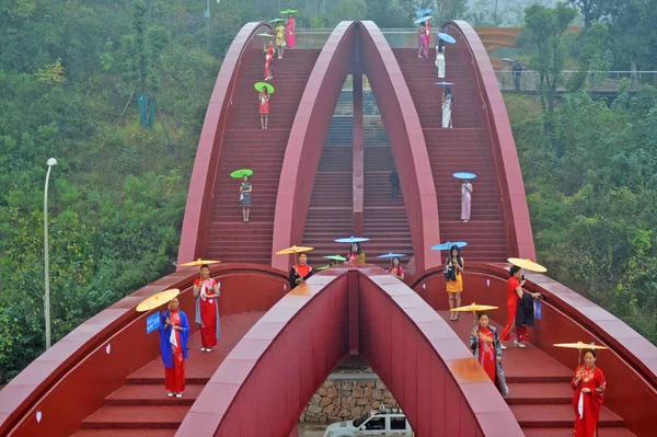 中国の女性は 2016 日中国中央部湖南省長沙市で結び目の形をした歩行者専用橋のテーラーを表示します — ストック写真