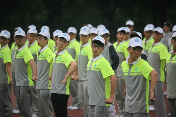 身穿荧光制服的中国青年学生参加2016年8月30日在中国重庆邮电大学举行的军事训练课程 — 图库照片