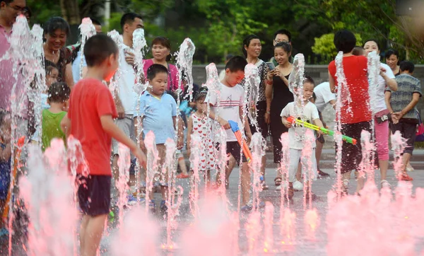 2016 日中国東部の江蘇省揚州市の焼け付くような日にクールダウンして噴水の水と遊ぶ中国の子供たち — ストック写真