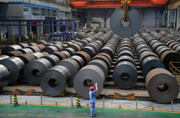 中国の労働者は 2014年8月13日 中国北部の河北省半安市にある河北鉄鋼グループの製鉄工場の倉庫でコイル状鋼板のロールを持ち上げるようクレーンに指示した — ストック写真