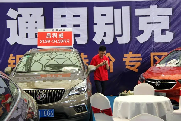 Chiński Człowiek Używa Swojego Telefonu Komórkowego Obok Samochodów Buick Saic — Zdjęcie stockowe