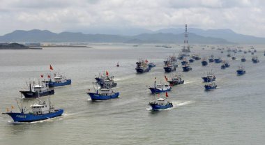 A fishing fleet departs from a harbor after the summer fishing moratorium ended in Zhoushan city, east China's Zhejiang province, 1 August 2016 clipart