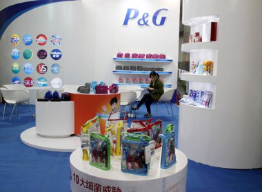A visitor uses her mobile phone at the stand of P&G (Procter & Gamble) during an exhibition in Beijing, China, 13 March 2014 clipart
