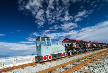 Tourists take a sightseeing train as they visit the Chaka Salt Lake (Caka Salt Lake) in Ulan county, Haixi Mongol and Tibetan Autonomous Prefecture, northwest China's Qinghai province, 18 July 2016 clipart