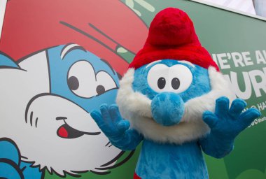 An entertainer dressed in a Smurf costume waves during the 
