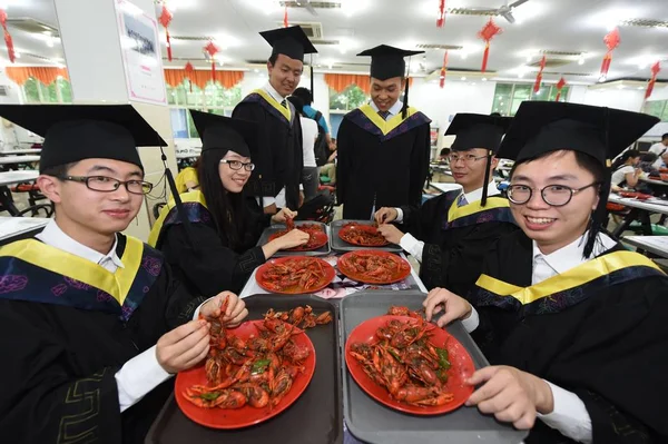アカデミック ガウンを着た中国人卒業生は南京市の航空宇宙大学の食堂でザリガニを食べ 東中国の江蘇省 月2016 — ストック写真