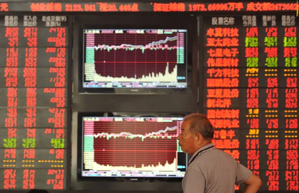 Chinese Investor Walks Screens Displaying Stock Indices Prices Shares Red — 图库照片