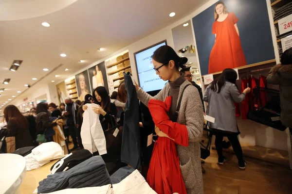 中国の上海でのユニクロのファッション店で服のための中国の顧客の買い物 月2016 — ストック写真
