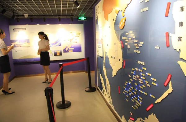 中国のガイドは 2016年7月12日 中国東部の江蘇省南京市の国防教育センターで 南シナ海と南沙諸島の地図の横にある訪問者に話す — ストック写真