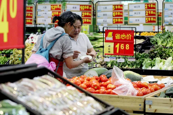 中国の顧客は 中国東部の江蘇省南京市のスーパーマーケットで野菜を買い物をする 2016年6月30日 — ストック写真