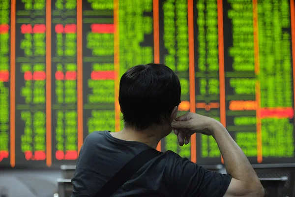 2016 日中国東部の浙江省杭州市の証券の家で 赤の価格上昇 と価格下落のため緑の株式の価格を見て懸念している中国語の投資家 — ストック写真