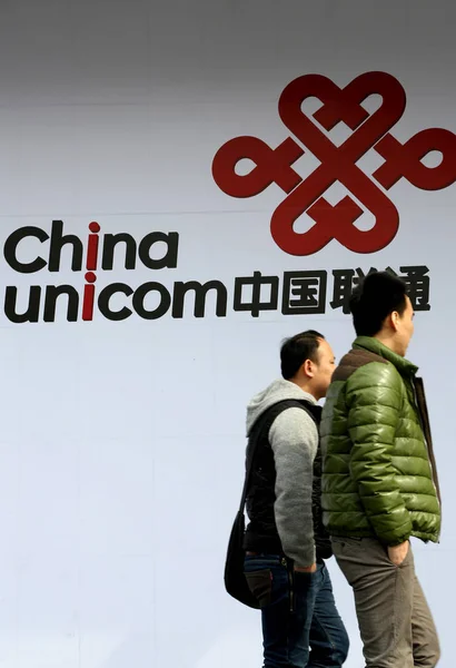 File 歩行者は 中国のユニコムの広告を通り過ぎる 2015年3月11日 — ストック写真