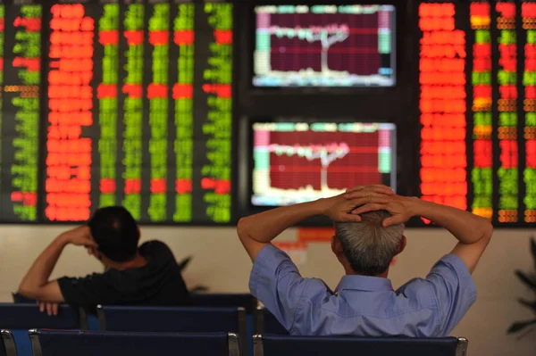 2016 日中国東部の安徽省阜陽市の証券会社の家で 赤の価格上昇 と価格下落のため緑の株式の価格を見て関係中国の投資家 — ストック写真