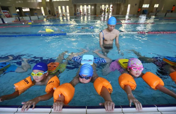 中国のコーチは 幼い子供たちにスコッチャーでスイミング ホールのプールで水泳を学ぶように指示している 東中国江蘇省の南通市 2016 月21日 — ストック写真
