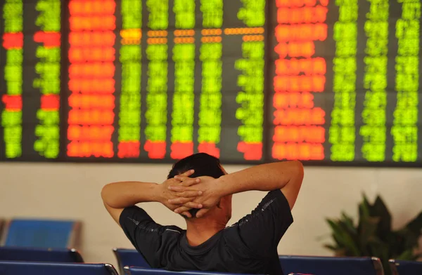 2016 日中国東部の安徽省阜陽市の証券会社の家で 赤の価格上昇 と価格下落のため緑の株式の価格を見て懸念している中国語の投資家 — ストック写真