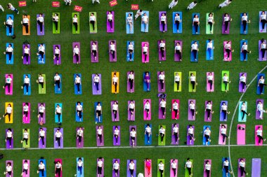 Chinese enthusiasts dressed in white perform yoga under the instructions of Indian yoga masters Shitanshu Sharma and Jitendra Kumawat to mark the International Yoga Day, which falls on June 21 every year, in Huaxian county, central China's Henan prov clipart