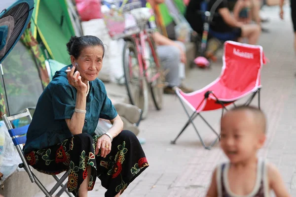 2017年6月28日 在中国东北黑龙江省哈尔滨市 一位老年妇女坐在一所公立幼儿园附近的帐篷前排队登记 — 图库照片