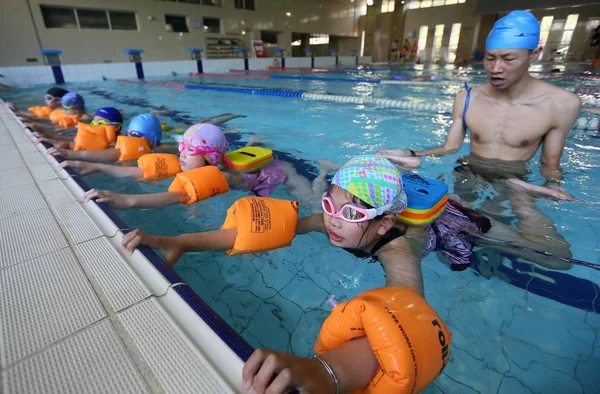 中国のコーチは 幼い子供たちにスコッチャーでスイミング ホールのプールで水泳を学ぶように指示している 東中国江蘇省の南通市 2016 月21日 — ストック写真