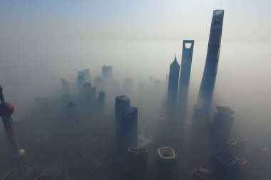 The Shanghai World Financial Center, second tallest, the Shanghai Tower, tallest, the Jinmao Tower, third tallest, and other high-rise buildings and skyscrapers are seen vaguely in heavy fog in the Lujiazui Financial District in Pudong, Shanghai, Chi clipart