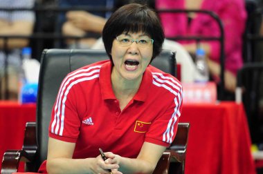 Head coach Jenny Lang or Lang Ping of China reacts as she watches her players compete against Japan during their international women's volleyball friendly match in Shenzhen city, south China's Guangdong province, 27 April 2016 clipart