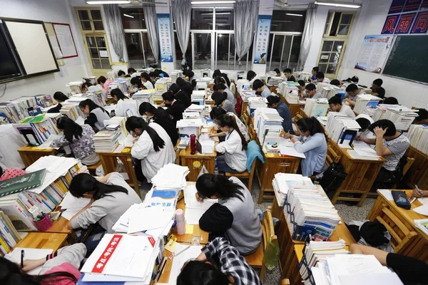 中国人留学生が今後国立大学入学試験とも呼ばれる Gaokao 2016 日中国東部の江蘇省連雲港市楡シニア中学生に教室での準備のために教科書を確認します — ストック写真