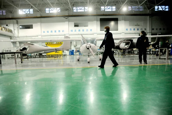 中国の労働者は 中国北東部の遼寧省の浙陽市の工場で組み立てられているRuixiang Rx1E電気飛行機を通り過ぎる 2015年12月3日 — ストック写真