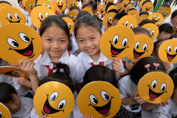 若い中国人の学生は笑顔で 5月8日 中国の河北省 邯鄲市の Fuhe 学校で5月に落ちる次の世界のスマイルデーを祝うために笑顔の切り抜きを抱きしめます2016 — ストック写真