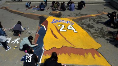 Chinese students put final touches on the giant portrait painting of NBA superstar Kobe Bryant to mark his retirement at Shenyang Sport University in Shenyang city, northeast China, Liaoning province, 14 April 2016 clipart