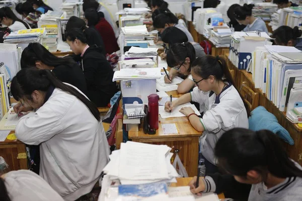 中国人留学生が今後国立大学入学試験とも呼ばれる Gaokao 2016 日中国東部の江蘇省連雲港市楡シニア中学生に教室での準備のために教科書を確認します — ストック写真