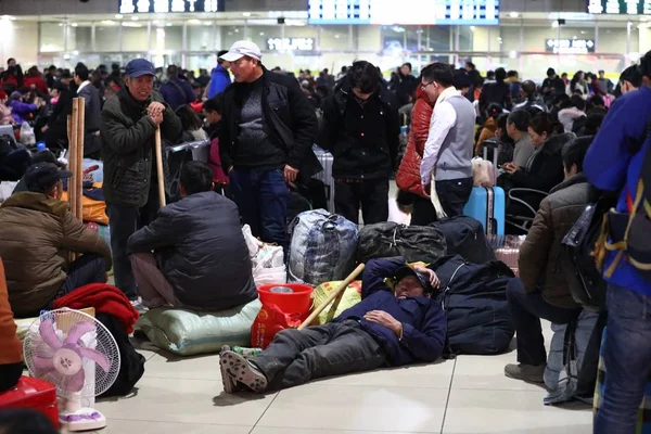 中国の出稼ぎ労働者やその他の乗客は 2019年1月17日 上海の上海駅で開催される中国の旧正月や春節に向けて列車が帰宅するのを待つ間 休息を取ります — ストック写真