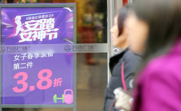 歩行者は 中国東部の山東省青島市のワンダプラザで店を通り過ぎる 2016年3月7日 — ストック写真