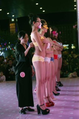 A female participant unbuckles the bras of lingerie-dressed models during a bra unbuckling competition to celebrate the Women's Day in Liuzhou city, south China's Guangxi Zhuang Autonomous Region, 8 March 2016 clipart