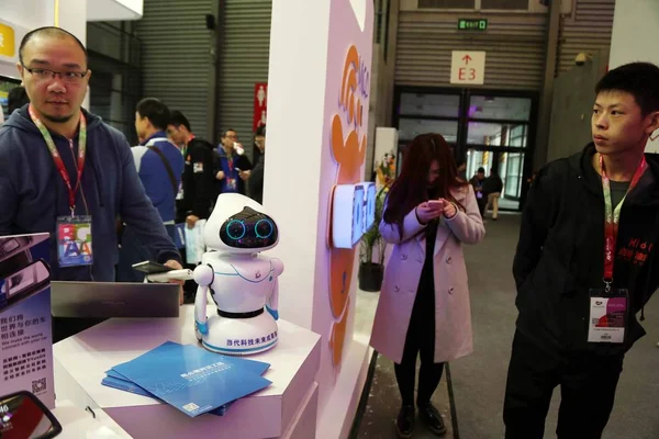 2016年3月9日 在中国上海举行的2016年家电世界博览会 Awe 一位游客走过展出的机器人 — 图库照片