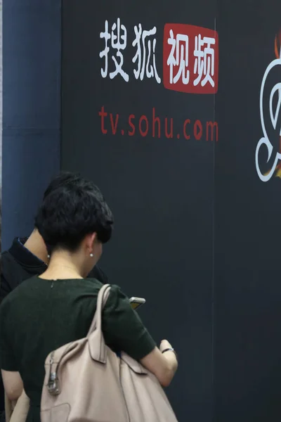 2014年11月20日 上海で開催された展覧会中に Sohuのオンライン動画サイトTv Sohu Comの広告の前で話す来場者 — ストック写真