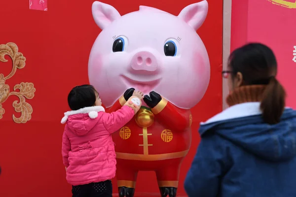 2019年1月17日 在中国南方广西壮族自治区南宁市一条街道上 一名儿童看着在庆祝春节或中国新年 的猪雕塑 — 图库照片