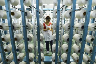 A female Chinese worker handles production of yarn at a textile factory in Megnshan county, south China's Guangxi Zhuang Autonomous Region, 18 October 2015.--CHINA OUT- clipart