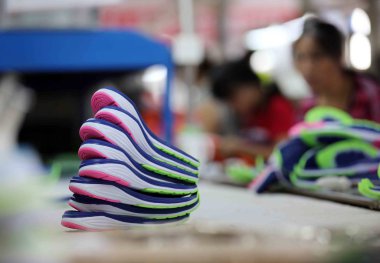 Chinese workers make soles of sports shoes at a factory in Jinjiang city, southeast China's Fujian province, 13 September 2015. --CHINA OUT- clipart