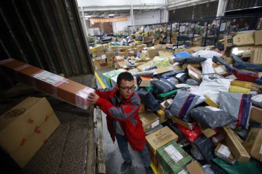 -A Chinese worker loads a van with parcels, most of which are from online shopping, at a distribution center of an express delivery company in Chongqing, China, 16 November 2015 clipart