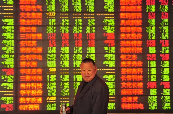在中国东部安徽省阜阳市一家股票经纪公司 一名关心中国的投资者在屏幕前显示股价 价格上涨为红色 价格下跌为绿色 — 图库照片