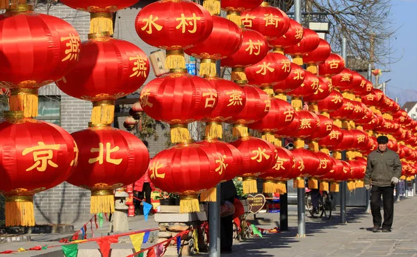中国の地元の村人が Yanxi 町の村 春祭りとして知られている中国の旧正月を祝うために通りに沿ってぶら下がった赤い提灯の弦を歩く2月2016 — ストック写真