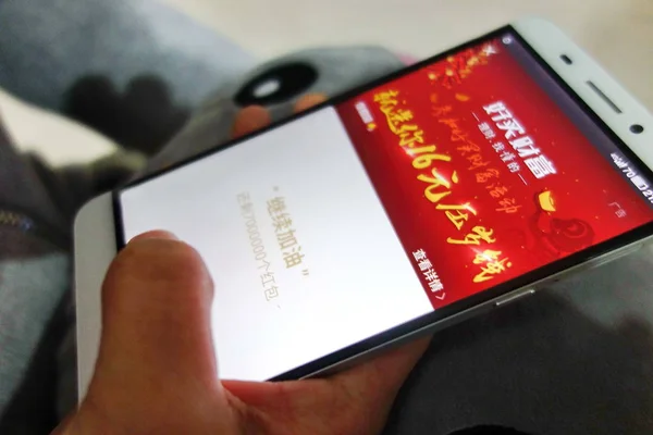 携帯電話のユーザーは Weixin Hongbao Wechatレッドエンベロープ 旧正月のための中国の伝統的な赤い封筒に相当するソーシャルメディア モバイルメッセージングアプリWeixin またはWechat 彼の上にテンセントの友人にお金を送ります — ストック写真