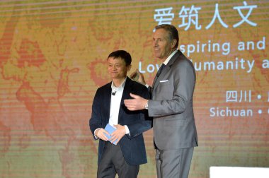 Howard Schultz, right, Chairman and CEO of Starbucks, speaks next to Jack Ma Yun, Chairman of Alibaba Group, at the 2016 Starbucks Partner Family Forum in Chengdu city, southwest China's Sichuan province, 12 January 2016. clipart