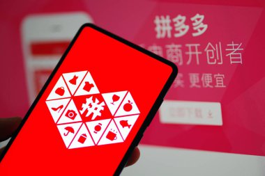 A Chinese mobile phone user uses the mobile app of Chinese e-commerce platform Pinduoduo on his smartphone in Ji'nan city, east China's Shandong province, 20 January 2019 clipart