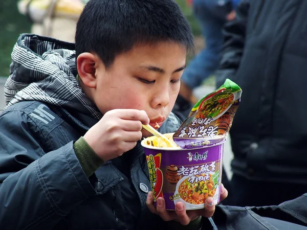 File Young Chinese Boy Eats Instant Noodle His Parents Wait — стоковое фото